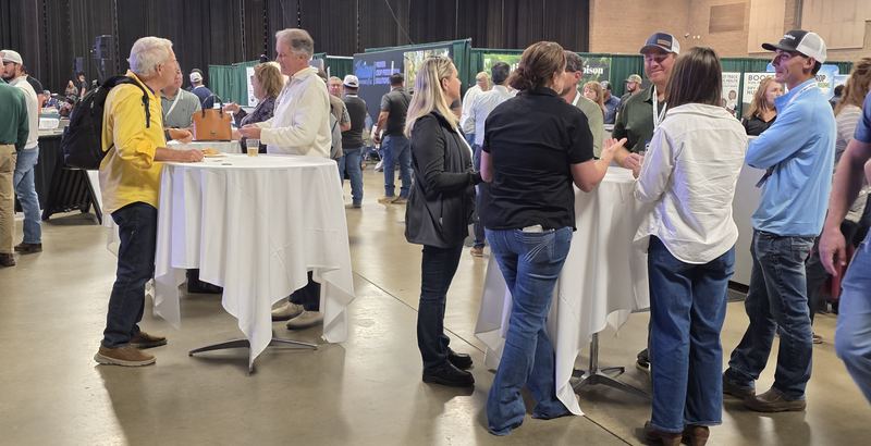 Attendees talking around high-top tables at the Day 1 mixer