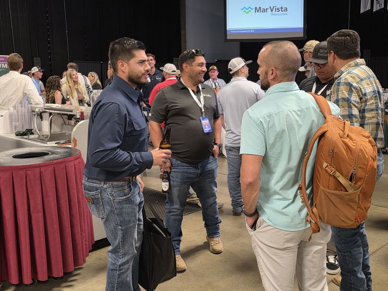 A group of attendees talking at the end of the Day 1 mixer
