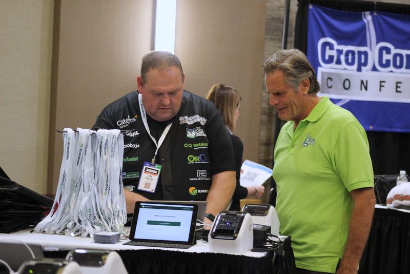 Jay Visser in the sponsor jersey helping an attendee at the registration desk