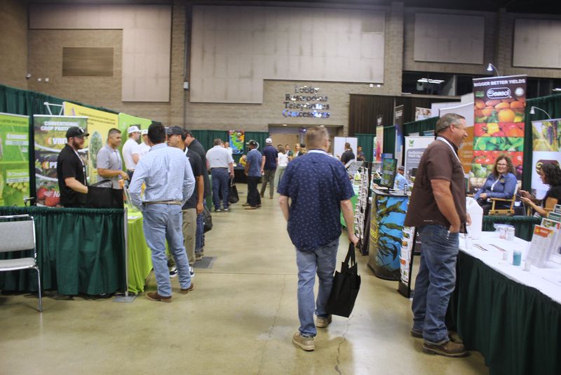 A busy aisle on the trade show floor with exhibitor booths on both sides