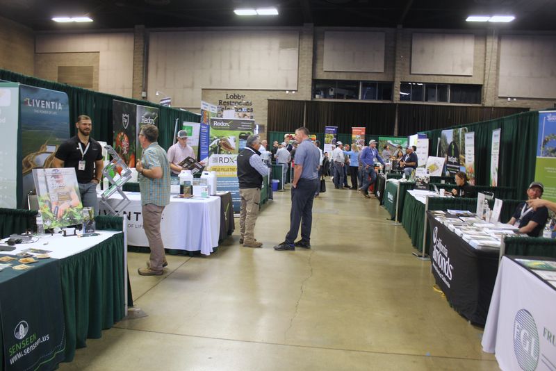 Attendees walking a trade show aisle between booths