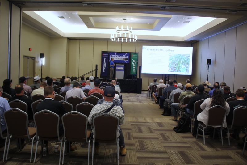 A breakout room filled with attendees watching a presentation on soil biology