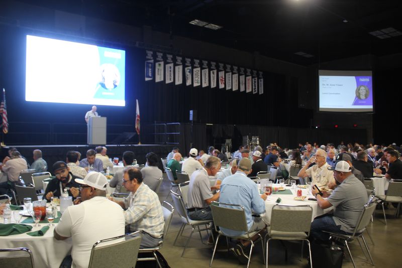 Attendees eating lunch at round tables in the Expo Hall