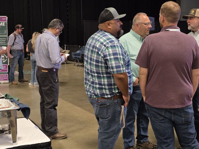 Four attendees standing in a circle talking on the trade show floor