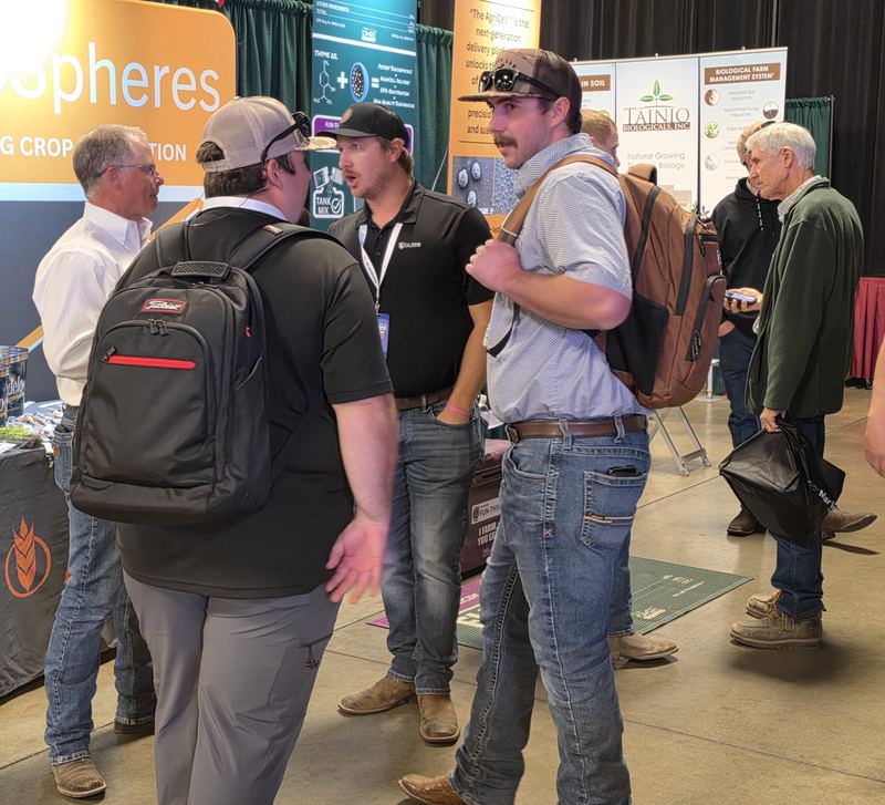 Attendees talking in front of the AgroSpheres booth