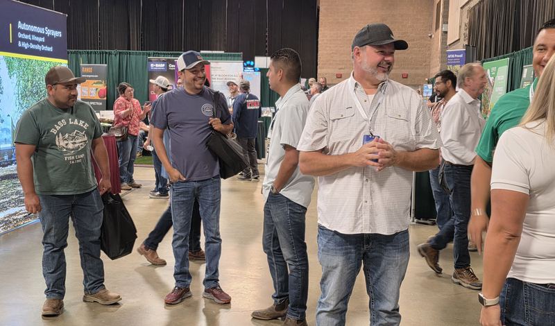 A group of attendees laughing together on the trade show floor