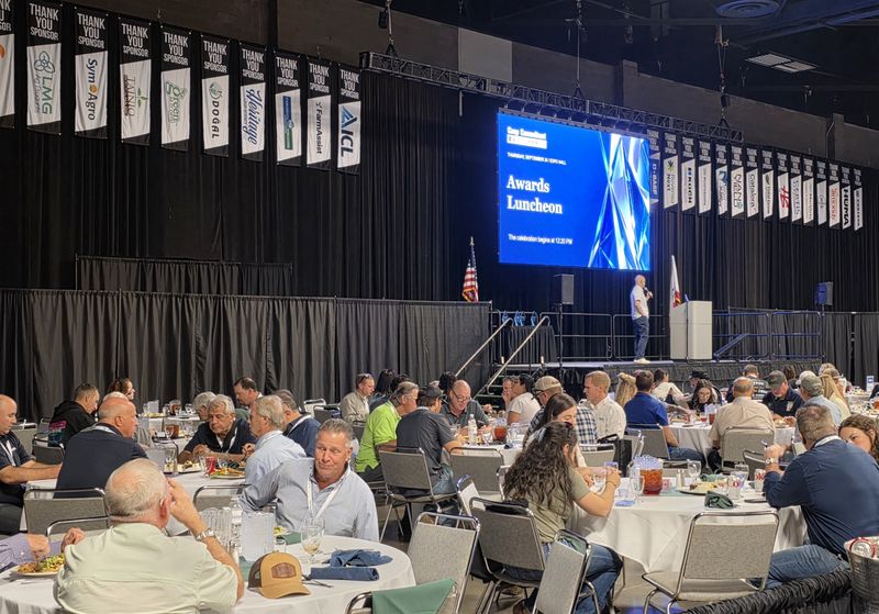 The Awards Luncheon title on the big screen over a full Expo Hall
