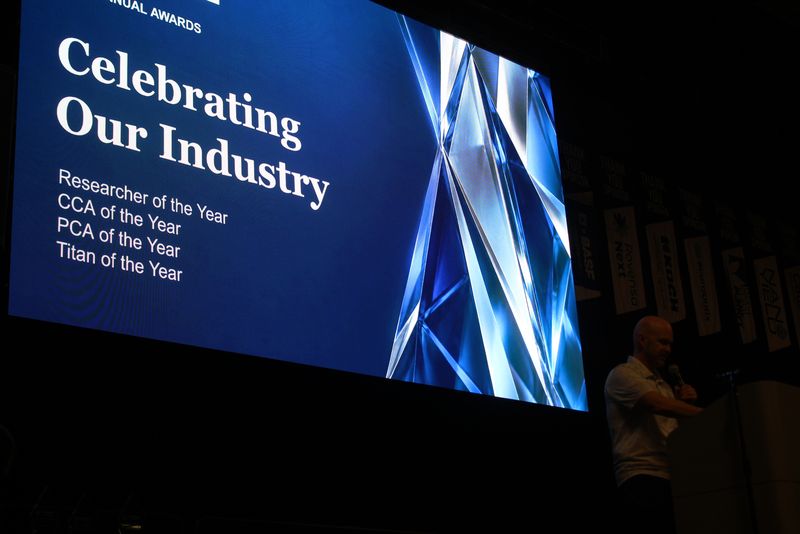 The Celebrating Our Industry awards slide on the big screen at the Day 2 luncheon